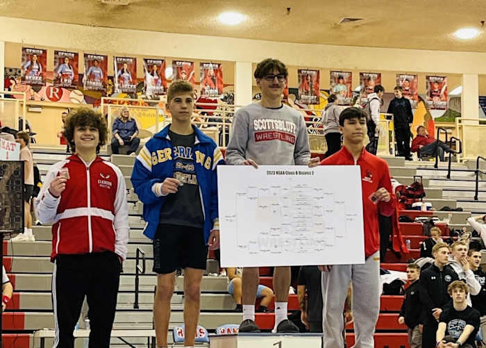 Scottsbluff senior Chance Houser stands atop the podium as the district champion earlier this season in Ralston. Houser is looking for a third straight state championship match and his first title as one of the best lightweight wrestlers in Nebraska. Photo from @kevingotgame15 on X.